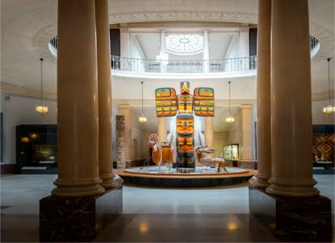 Museumzaal met zuilen en een totempaal